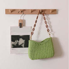 Load image into Gallery viewer, Chic woven straw bag with curved shoulder silhouette and statement chain strap, a stylish women's straw bag that works as a resort bag women love for summer outings and vacation styling, straw sling beach bag, wicker purse, resort bag.