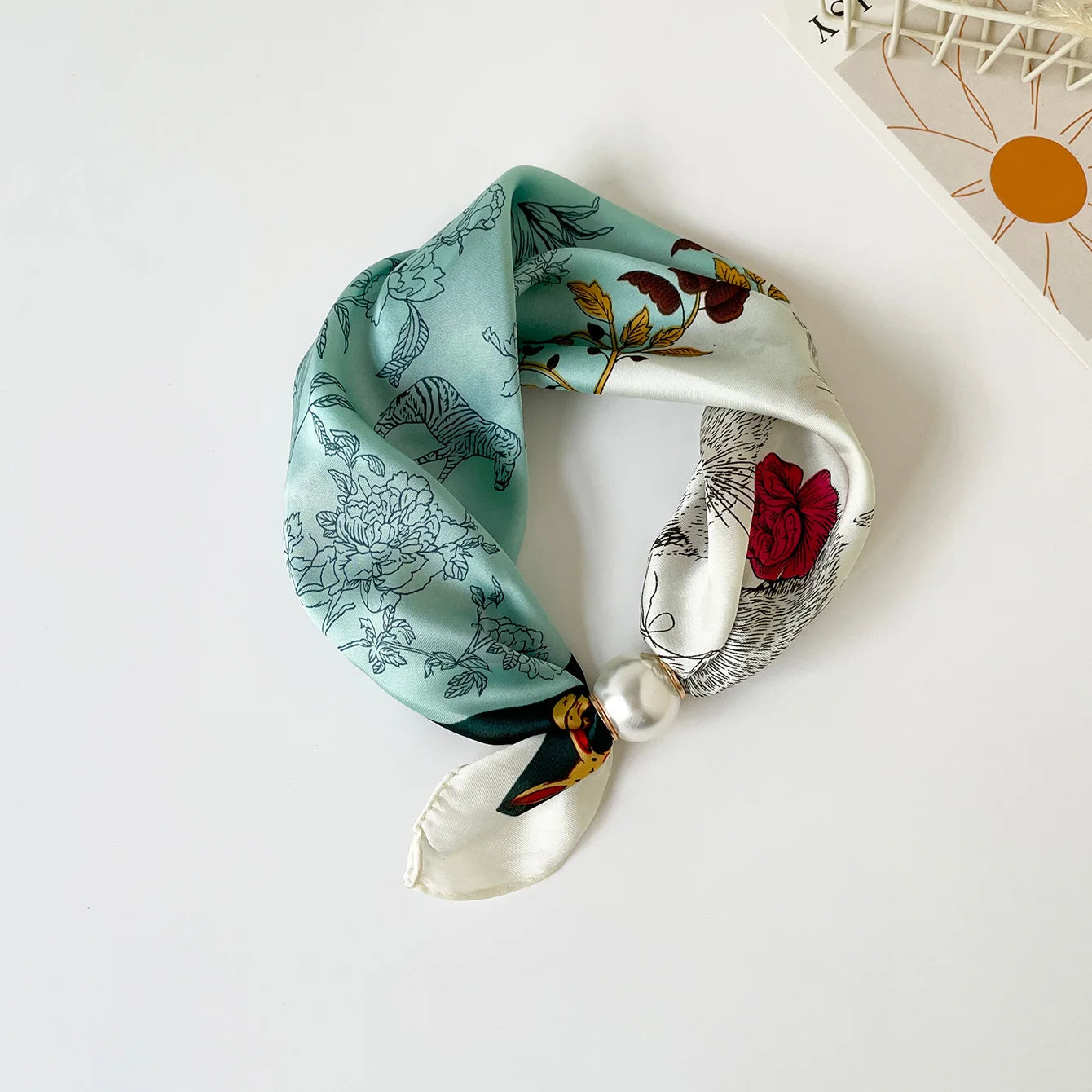 Printed faux silk scarf with a magnetic pearl fastening, perfect for travel wardrobes, European vacations, weekend brunches, and lightweight resort-inspired accessorizing.